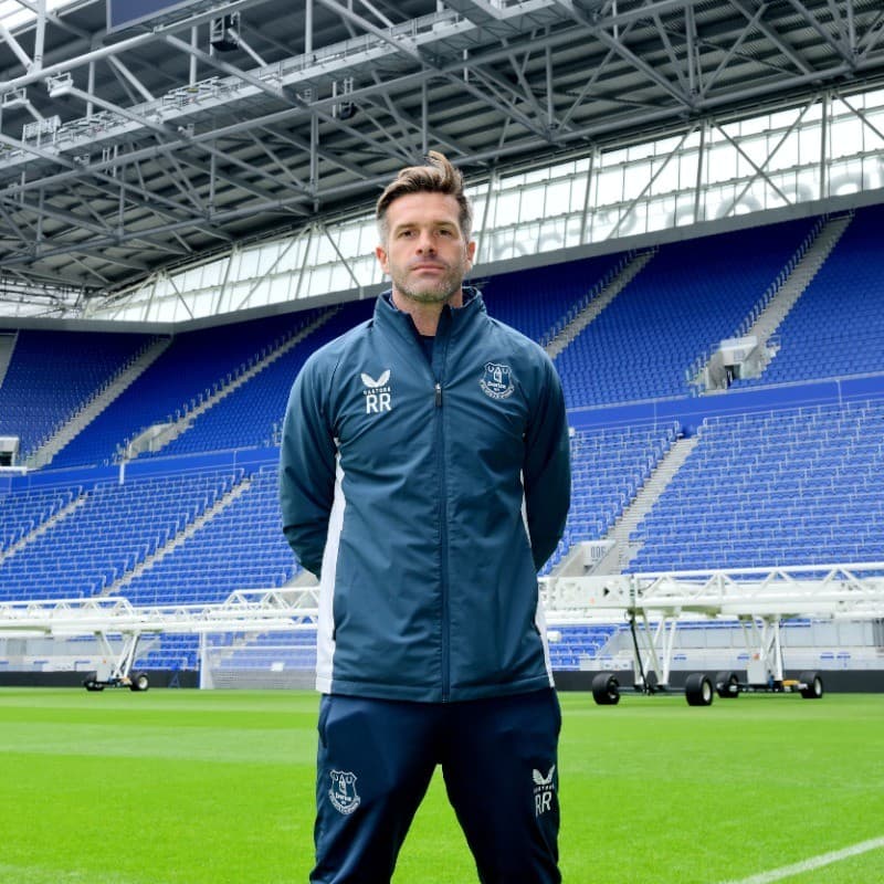 Ray Redmond, UEFA A Licensed coach, standing on the pitch in Everton training wear.
