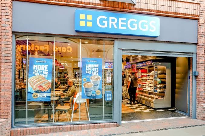 The storefront of a Greggs bakery on an English high street.