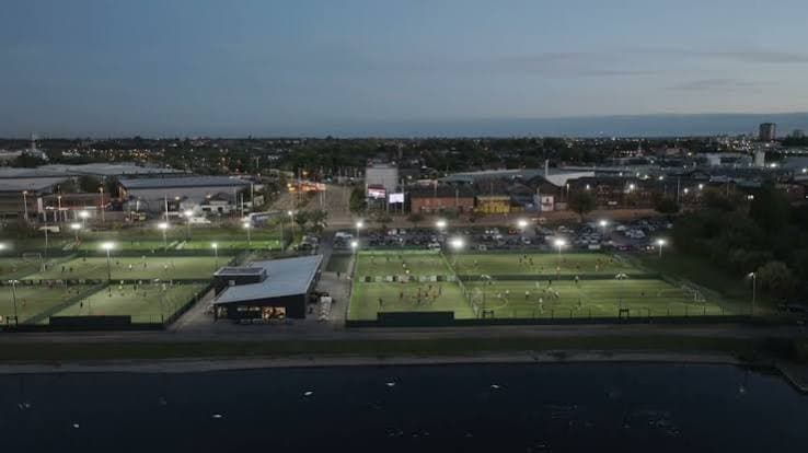 Floodlit small-sided football pitches at a Powerleague venue in the evening.