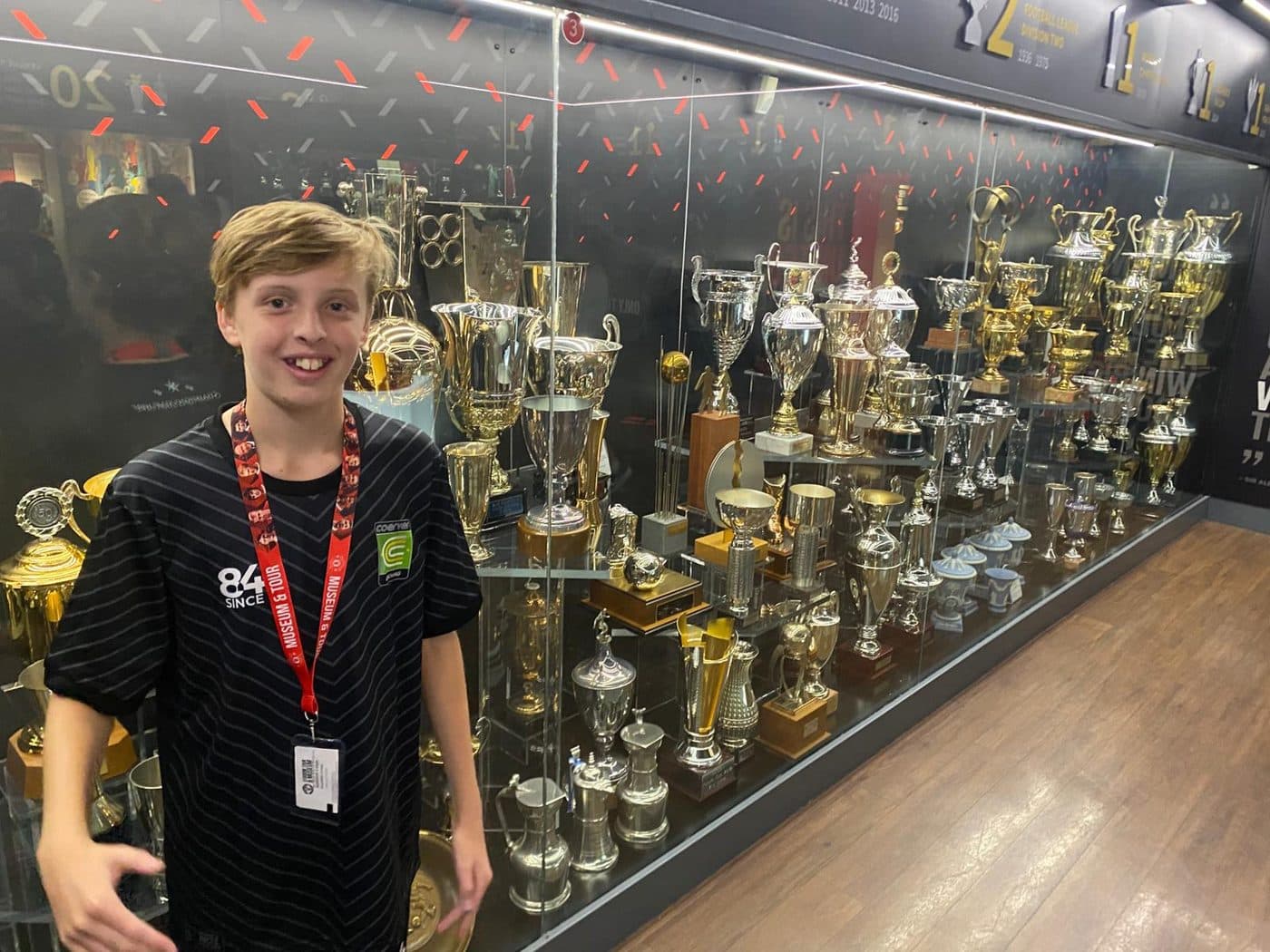 A young player at the Manchester United trophy cabinet on an IPPE soccer tour